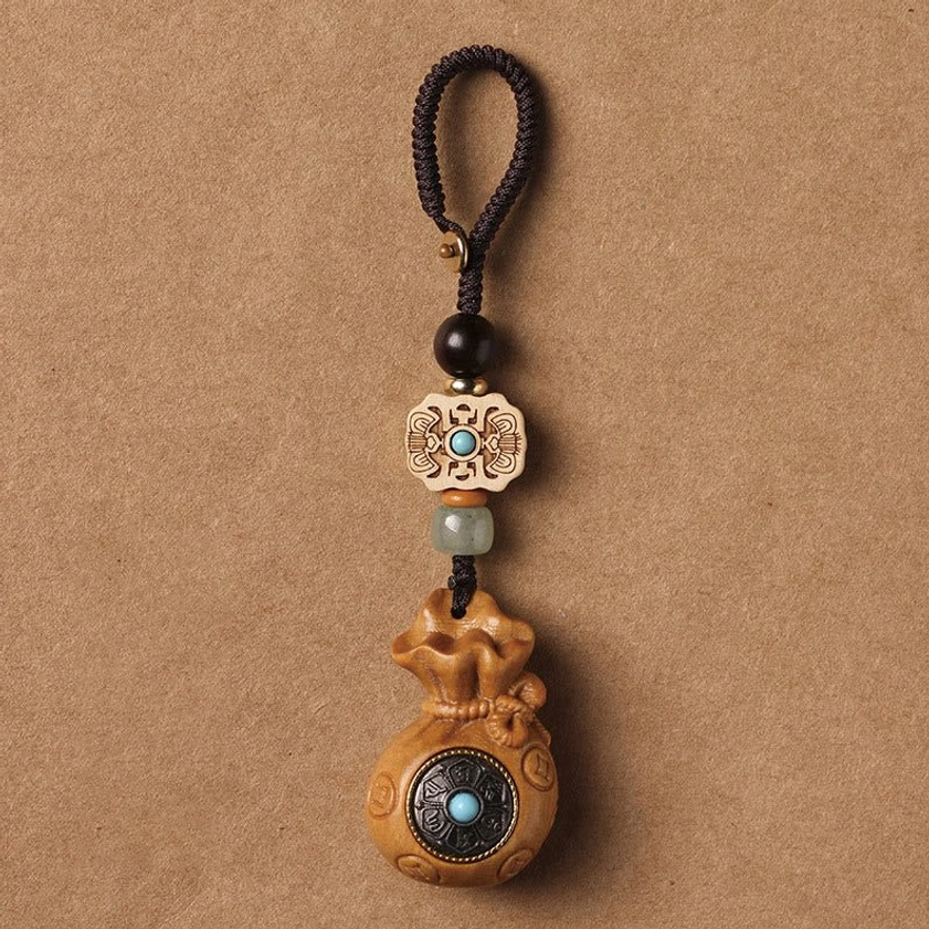 Premium sandalwood Om Mani Padme Hum keychain with carved beads and copper accents on neutral background