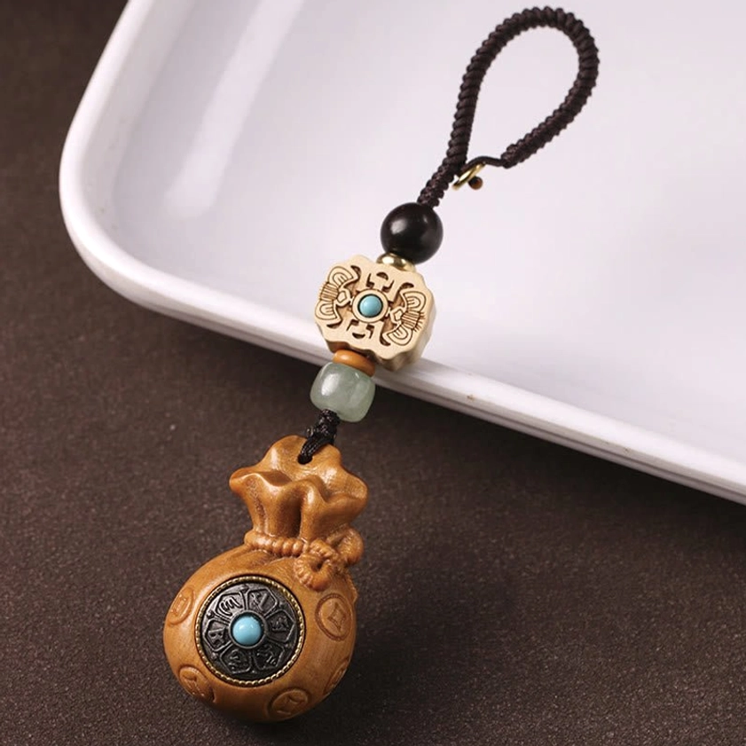 Sandalwood Om Mani Padme Hum charm showing carved Om symbol and Buddhist sacred geometry detail