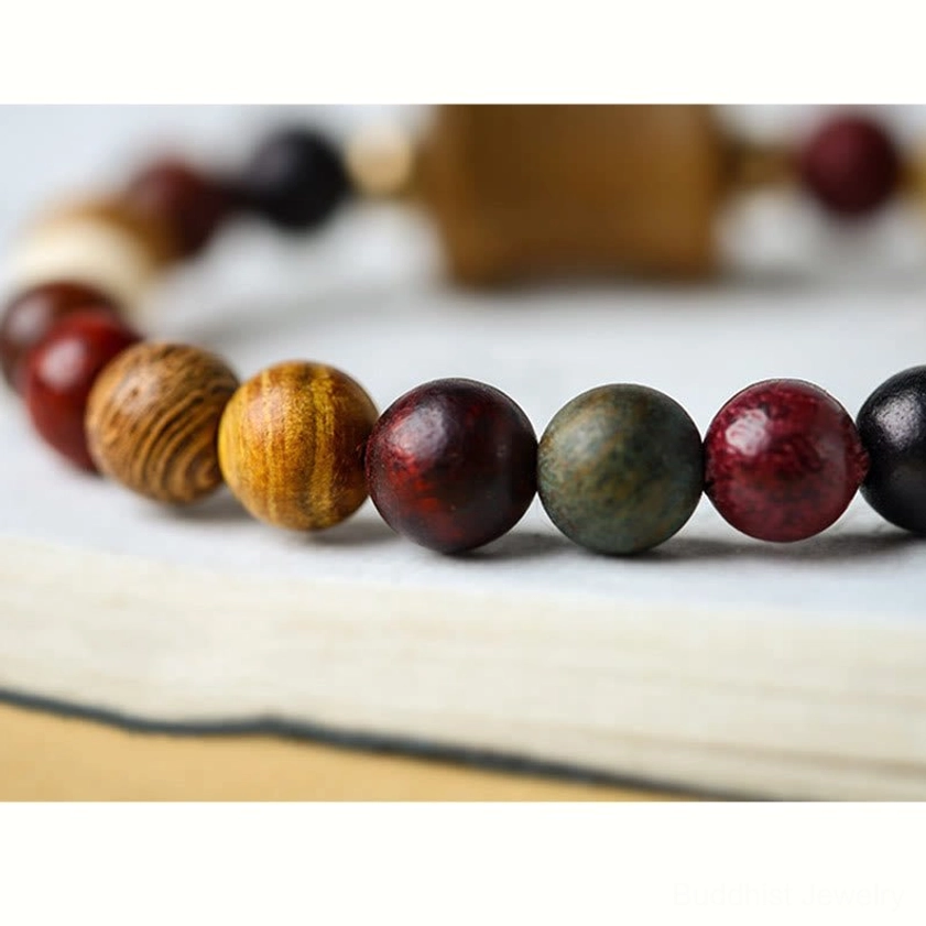 Shallow focus detail of multicolor sandalwood prayer beads showing polished wood texture and natural bead variations