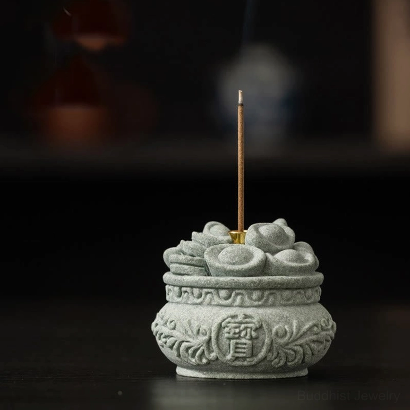 Close-up of handcrafted sandstone incense holder showing intricate carved patterns and prosperity symbols