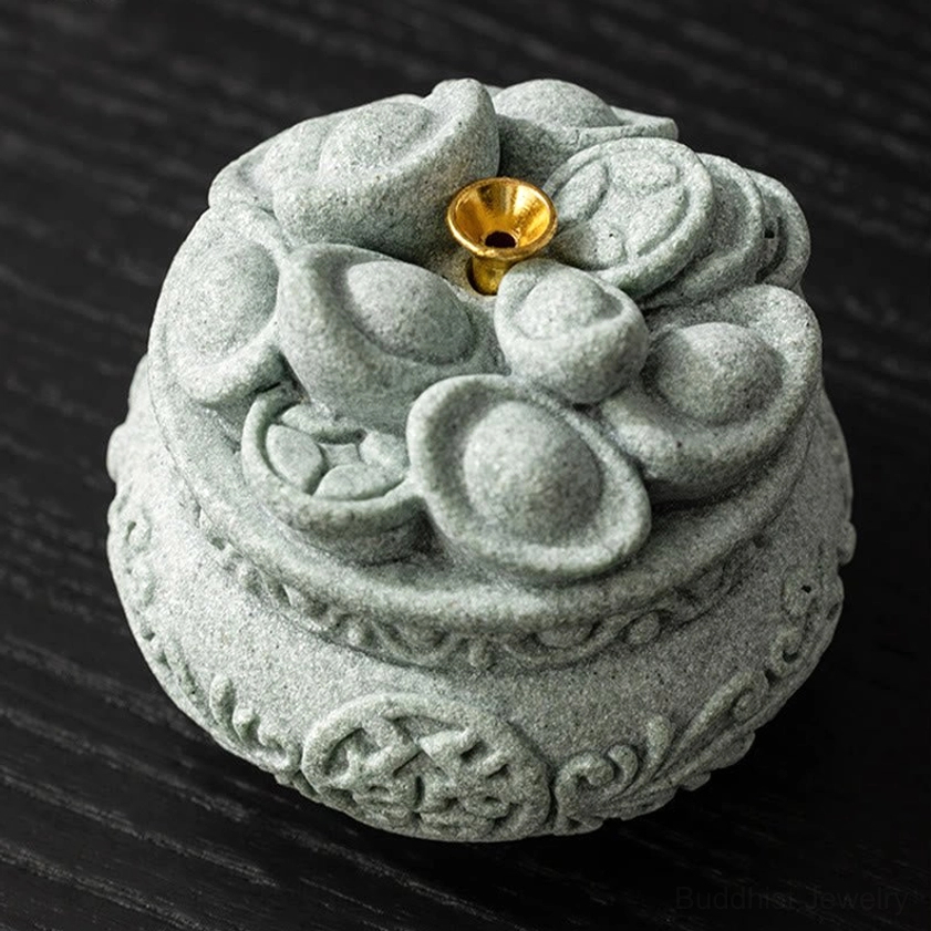 Buddhist incense holder showing matte sandstone finish and traditional carved motifs