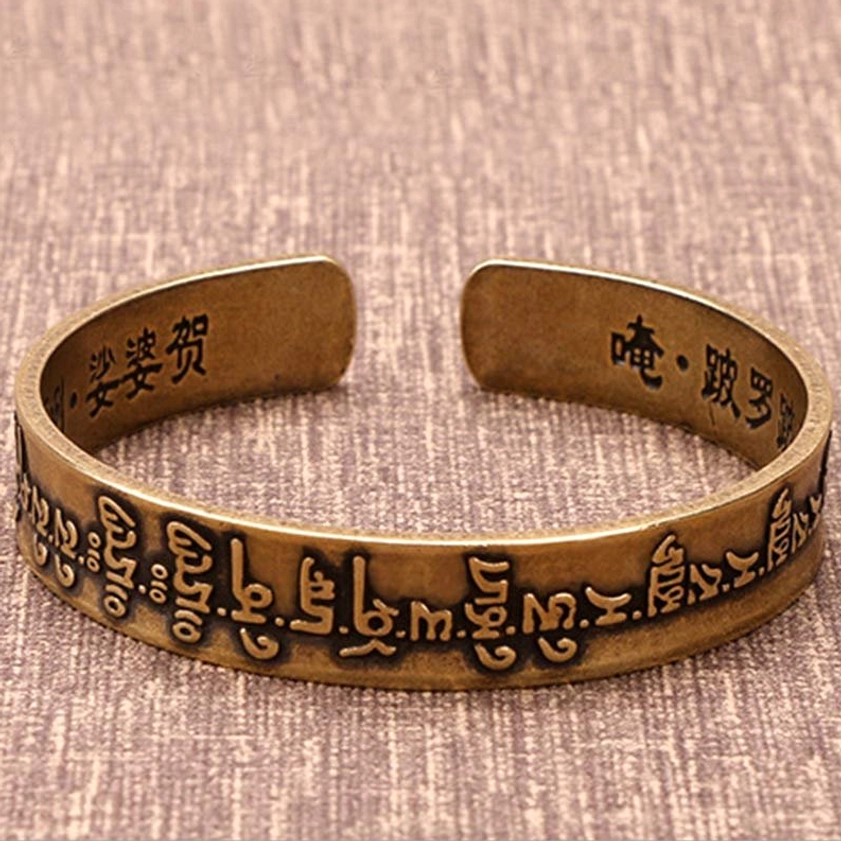 Front view of Buddhist Sanskrit mantra open cuff bracelet with raised relief text and adjustable brass design