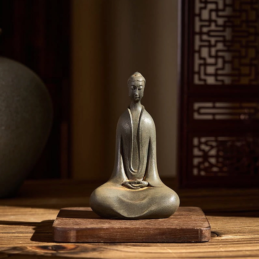 Seated Buddha figurine front view with traditional lattice backdrop, peaceful meditation pose