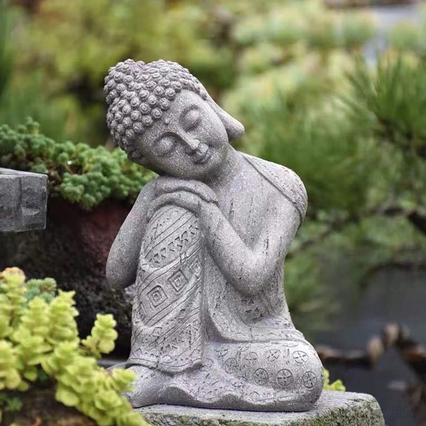 Handcrafted resin seated Buddha statue with intricate carved robe details and serene expression in garden setting