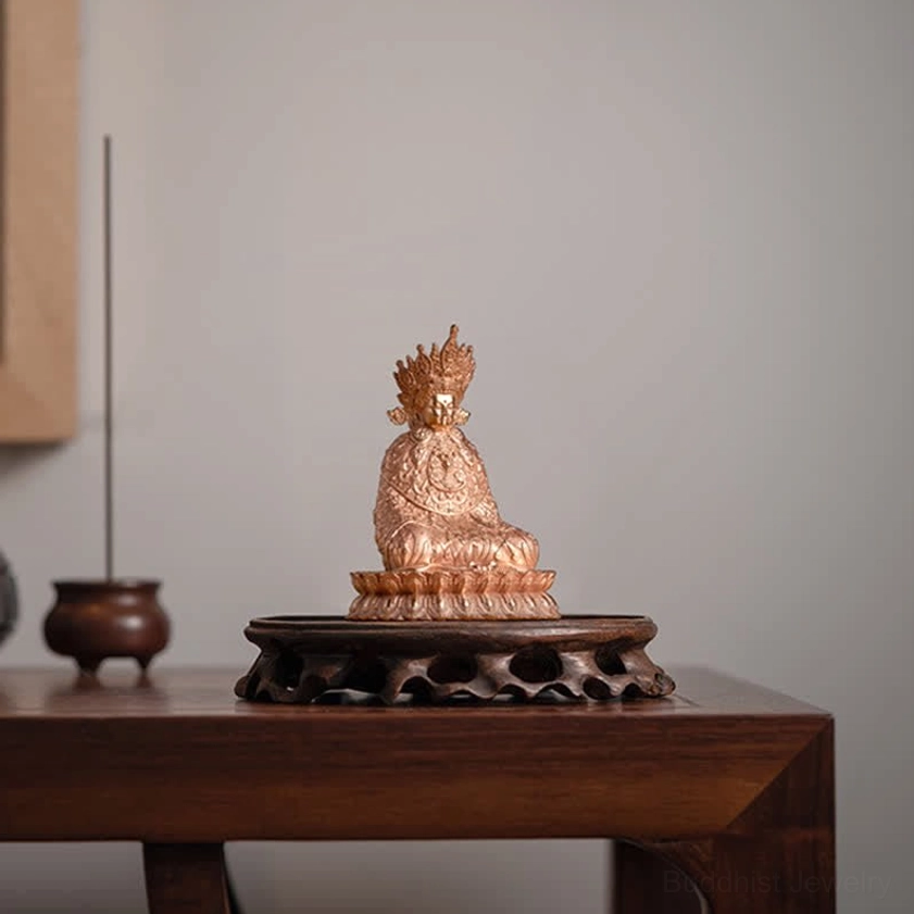 Compact copper Shakyamuni Buddha statue on carved wooden base with incense censer nearby showing meditation altar arrangement