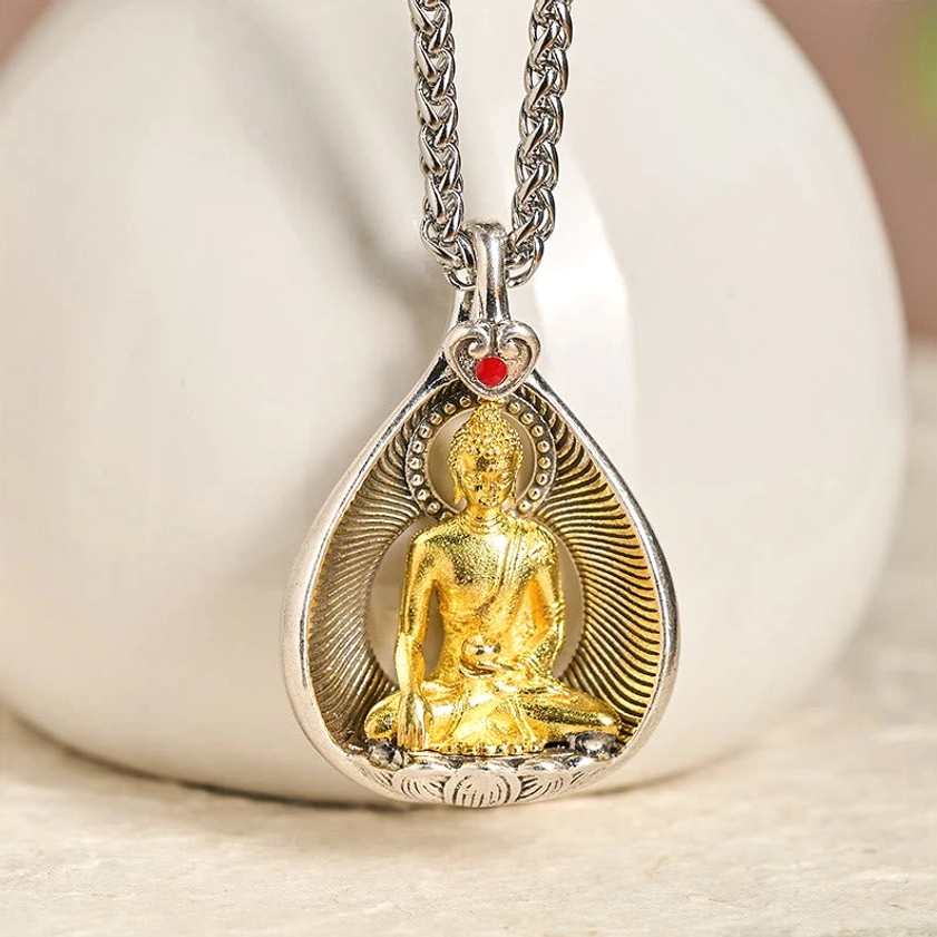 Shakyamuni Buddha Buddhist pendant necklace design featuring gilded statue with red gem heart clasp and silver frame