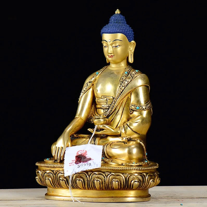 Shakyamuni Buddha copper statue front-left angle seated in earth-touching mudra pose with intricate robe details visible