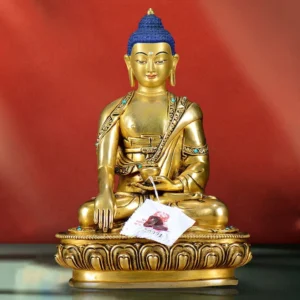 Shakyamuni Buddha earth-touching mudra copper statue front view with gilt bronze finish and blue curled hair, seated on lotus pedestal