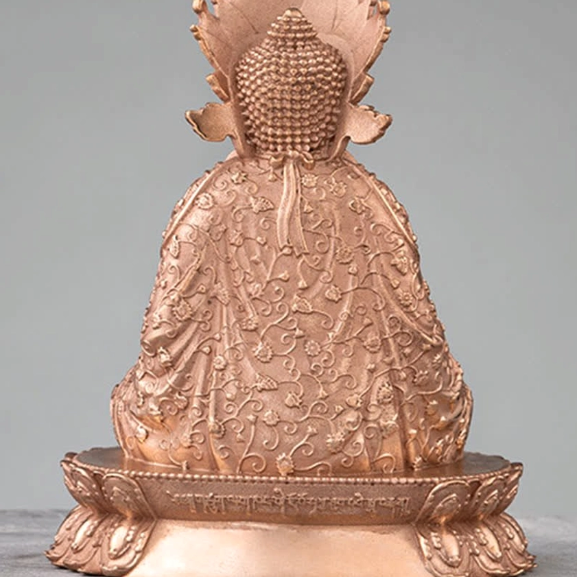 Close-up rear detail of handmade Buddha statue displaying elaborate back carvings and sacred engraved text on lotus base