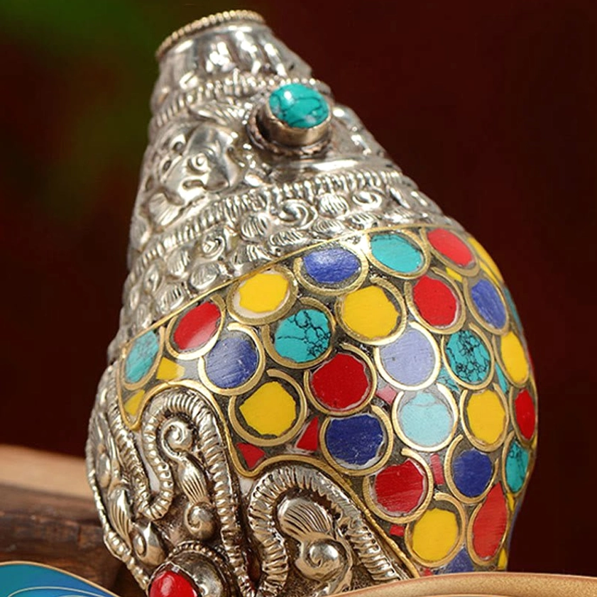 Macro close-up of shankha conch shell body showing dense multicolor circular enamel inlays and carved silver trim