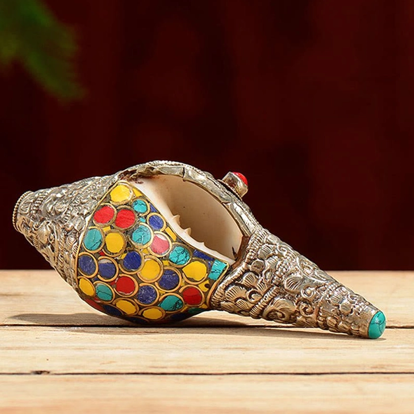 Open conch mouth view of handmade shankha ornament with intricate enamel inlays and carved silver trim