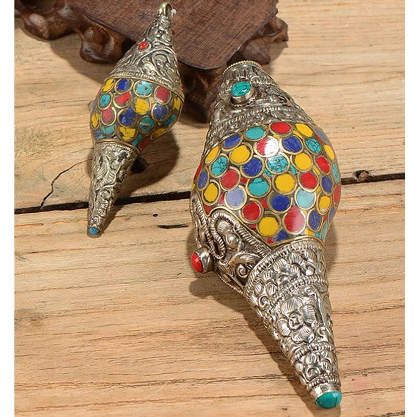 Side view of handcrafted conch shell shankha ornament showing multicolor inlays and turquoise gemstone base cap