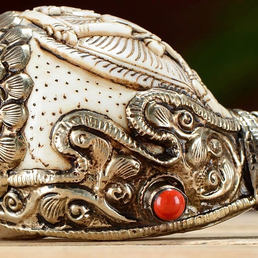 Ornate silver filigree and red gemstone inlay on carved shankha decoration