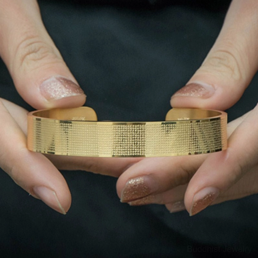 Hands holding Shurangama Mantra engraved titanium steel Buddhist blessing bracelet showing detail