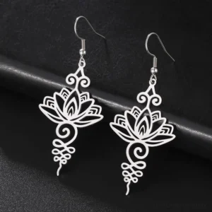 Silver hollow lotus flower drop earrings flat lay with intricate filigree design, Buddhist enlightenment jewelry