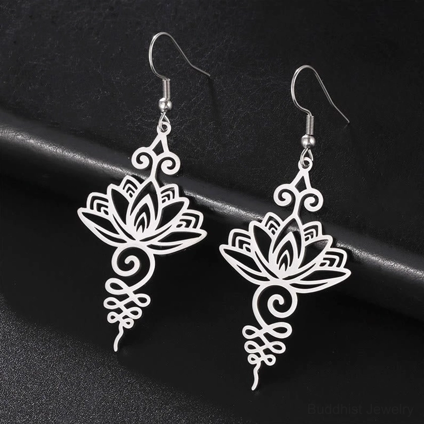 Silver hollow lotus flower drop earrings flat lay with intricate filigree design, Buddhist enlightenment jewelry