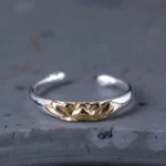 925 sterling silver lotus flower open cuff ring with embossed gold lotus motif front view on grey stone
