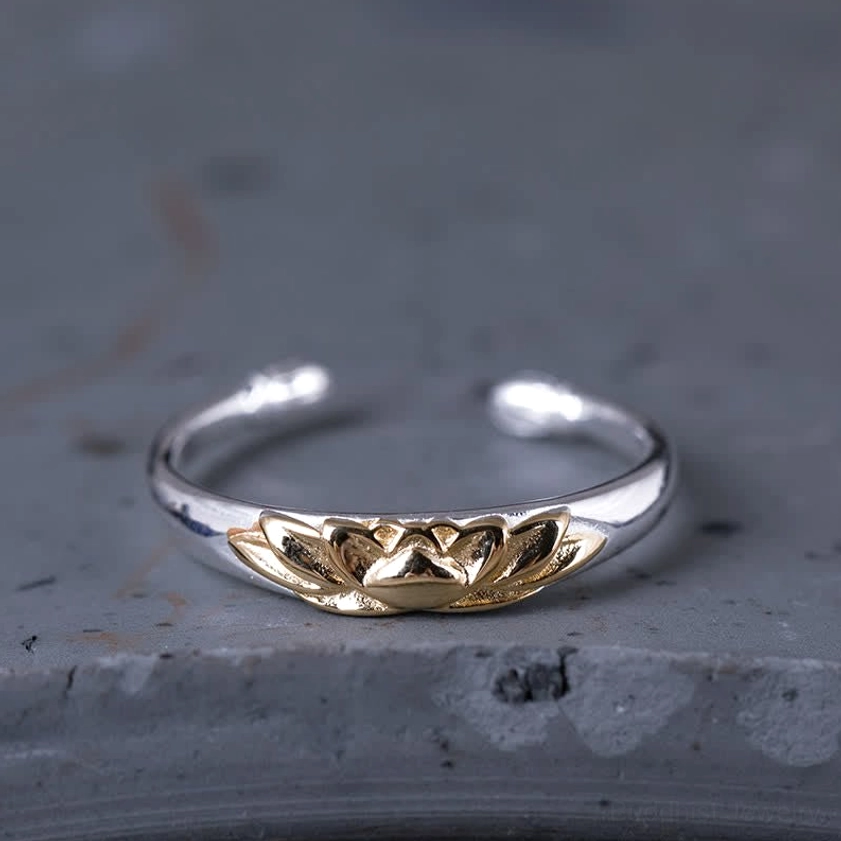 925 sterling silver lotus flower open cuff ring with embossed gold lotus motif front view on grey stone
