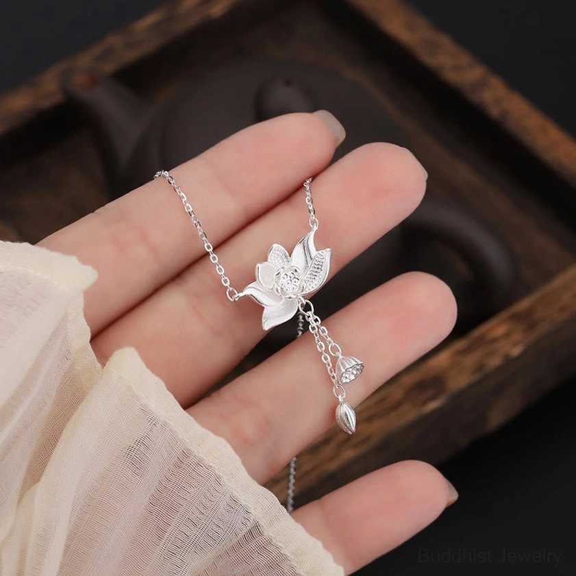 Close-up detail of 999 sterling silver hallmark stamp and spring ring clasp on white background, authenticity mark