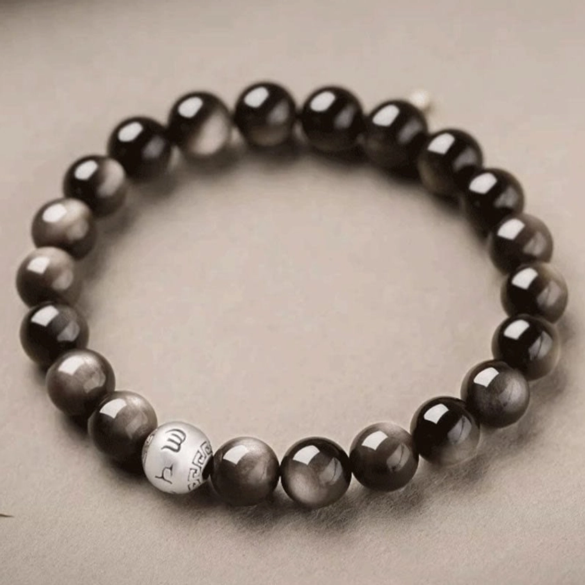 Full loop of handcrafted Silver Sheen Obsidian Buddhist bracelet with prominent engraved silver mantra beads and glossy sheen