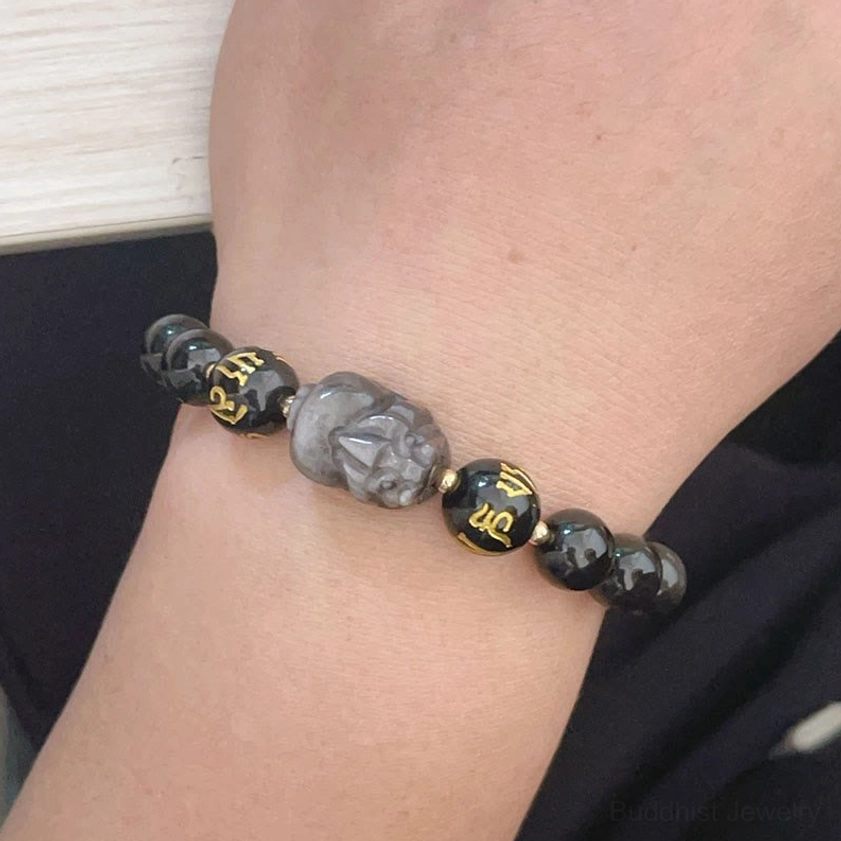 Close-up wrist view of Silver Sheen Obsidian Buddhist protection bracelet with Pixiu charm in everyday wear