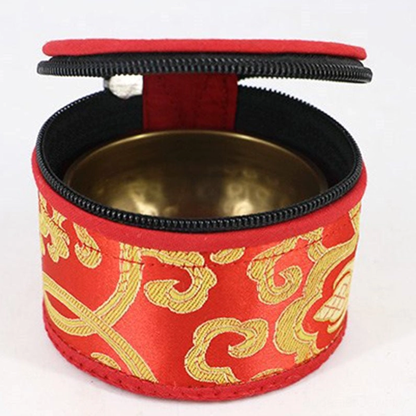 Open singing bowl storage bag displaying red brocade exterior and black inner lining