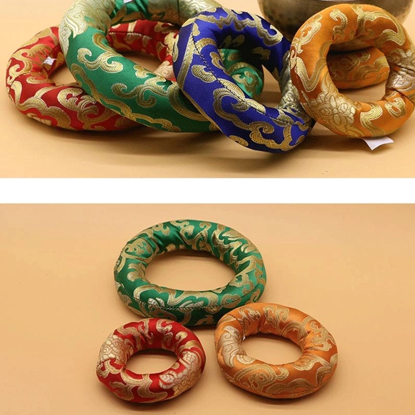 Four colorful Buddhist singing bowl meditation cushions displayed together, featuring golden scroll patterns and traditional brocade fabric