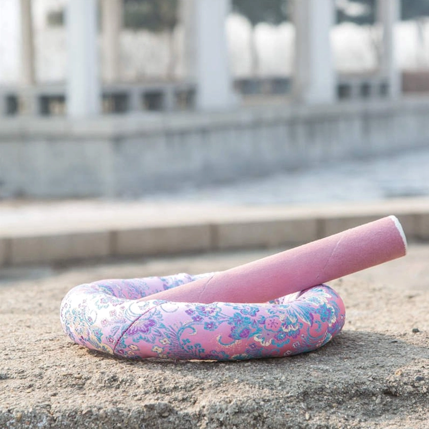 Singing bowl cushion and striker placed together on concrete showing tilted meditation setup