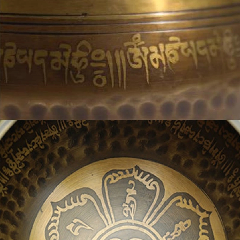 Singing bowl close-up texture details showing Sanskrit engravings, hammered dimpled surface, and central lotus pattern