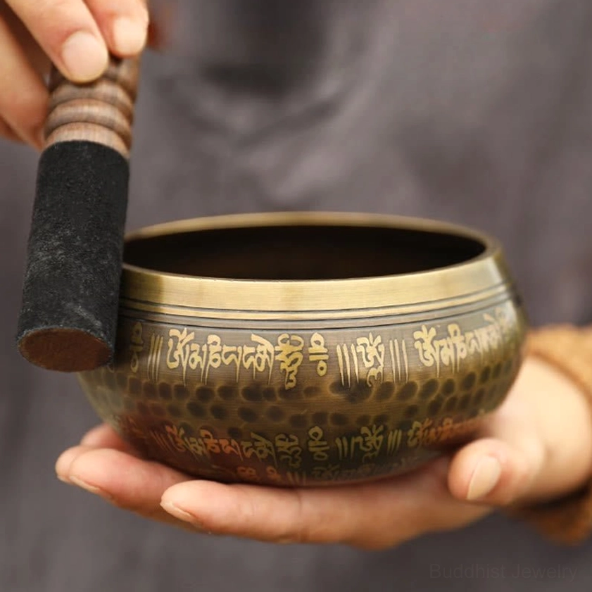 Meditation practice with singing bowl and leather-wrapped wooden mallet, demonstrating sound healing technique