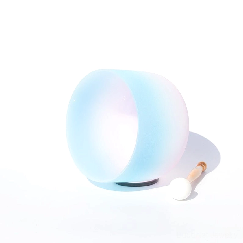 Profile view of frosted white crystal singing bowl showing ombre gradient effect with rubber base and wooden mallet
