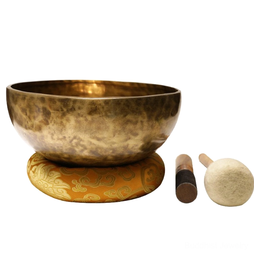 Singing bowl set with wooden mallets and yellow embroidered cushion for complete meditation practice