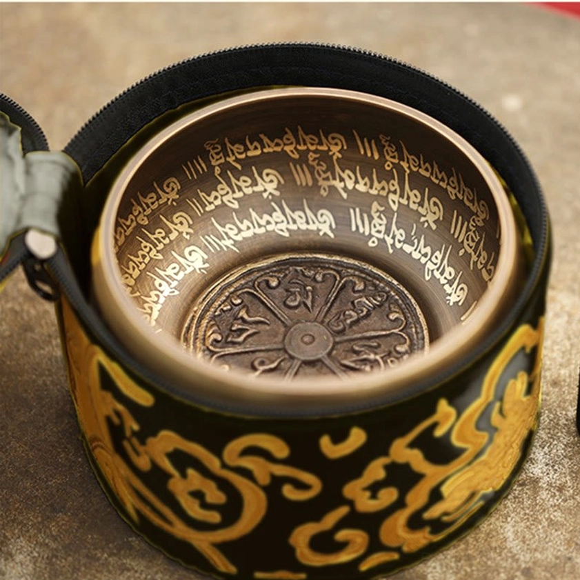 Buddhist singing bowl displayed in black and gold embroidered storage bag showing protective packaging
