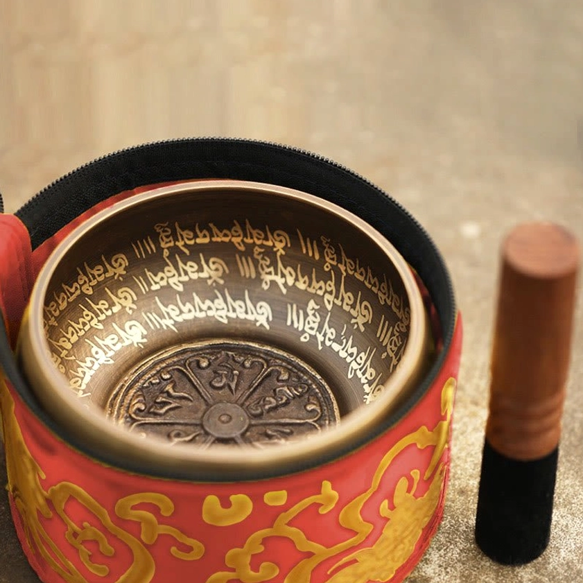 Buddhist singing bowl in red and gold embroidered storage bag with engraved inner mantras and Vajra pattern