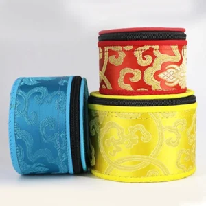 Multi-color singing bowl storage bags with gold brocade embroidery and zipper closure, flat lay view