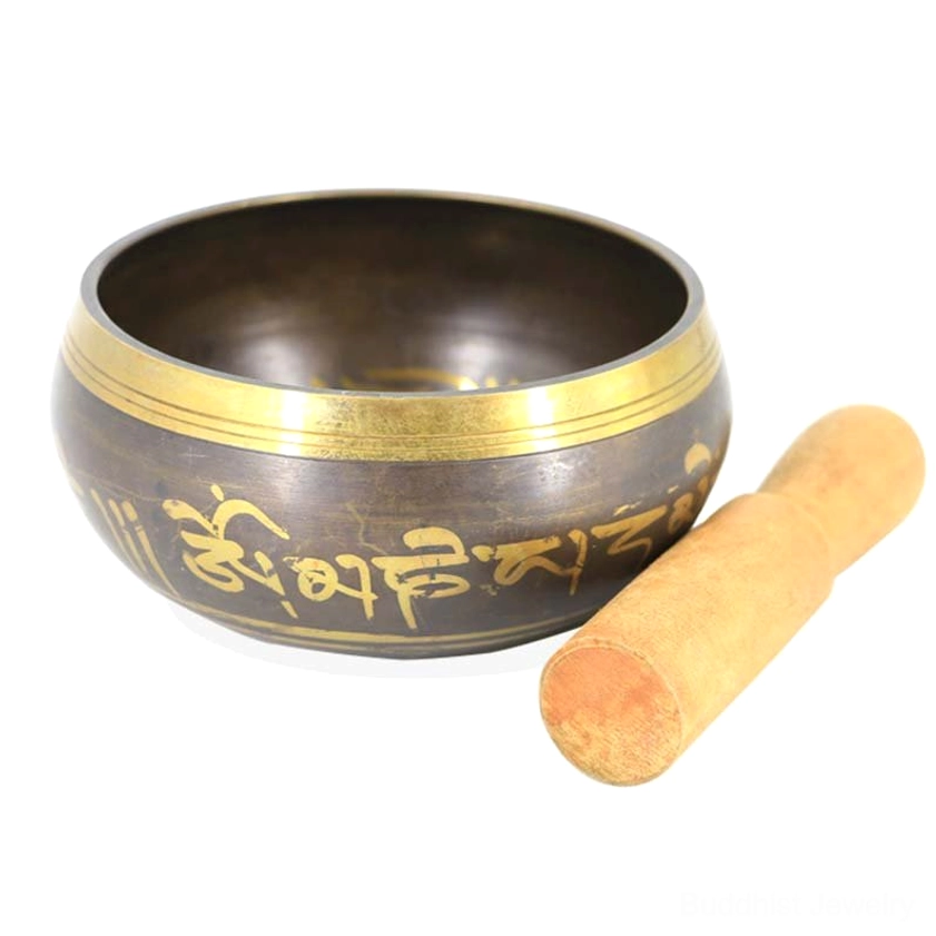 Buddhist singing bowl with Om Mani Padme Hum golden Sanskrit text displayed beside wooden mallet in flat lay setup on tabletop