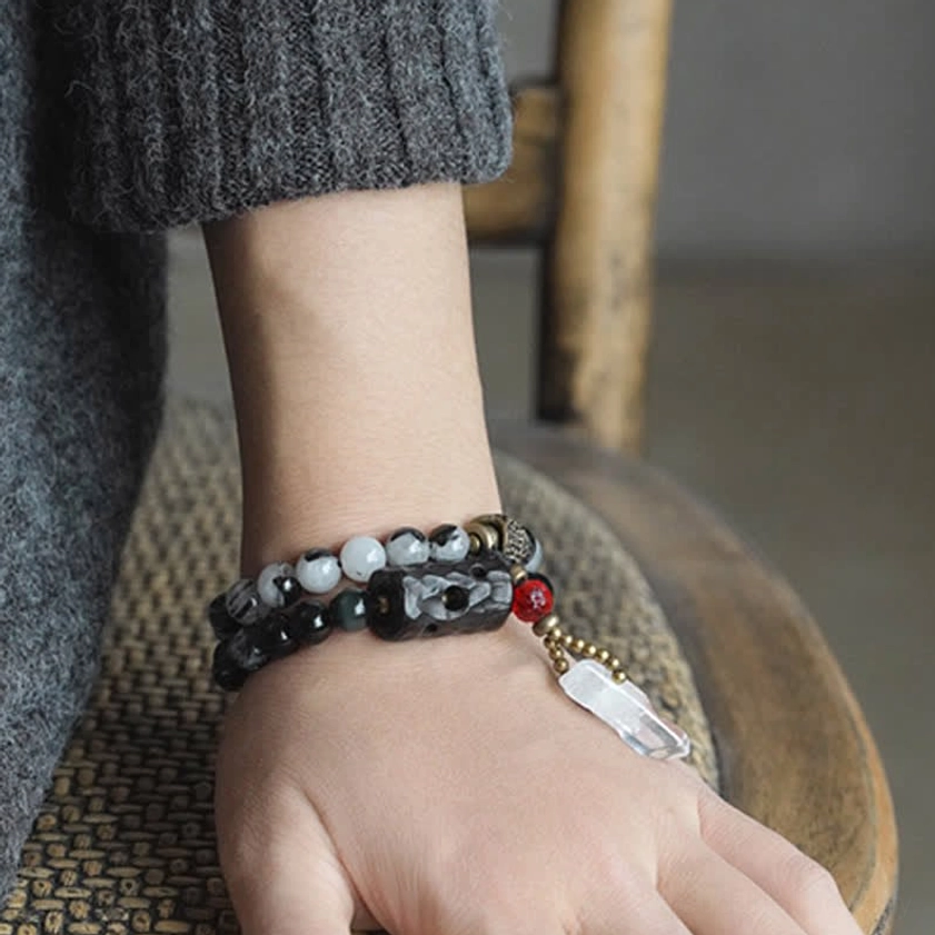 Single Black Rutilated Quartz bracelet with ebony wood charm on wrist showing carved details