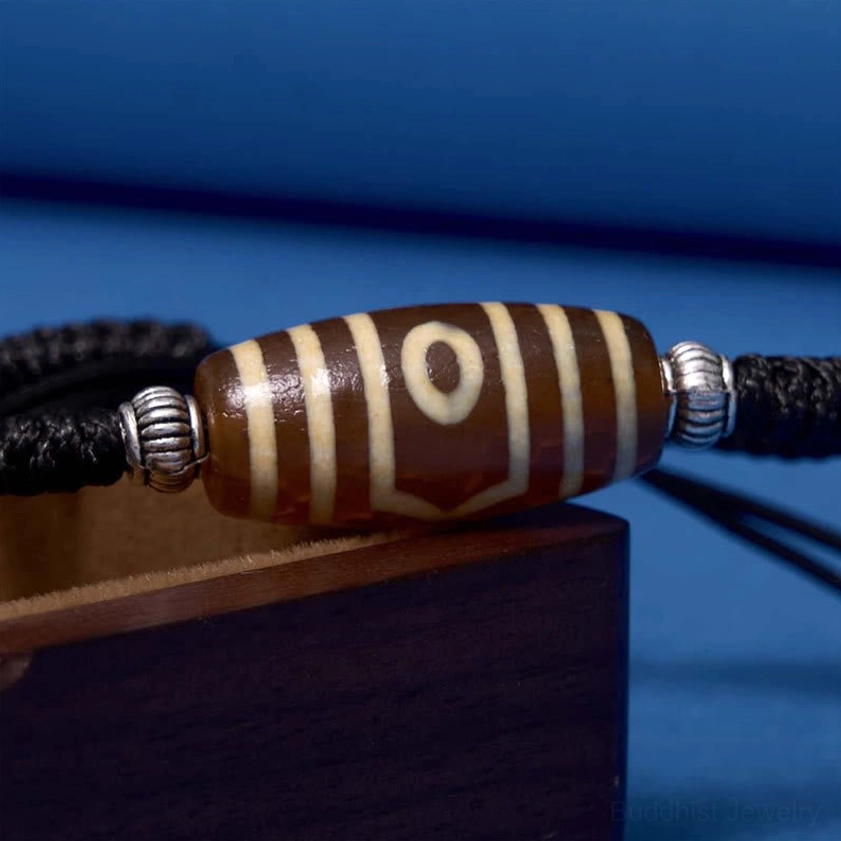 Six-eye dzi bead bracelet full circular layout on textured background showing symmetrical design
