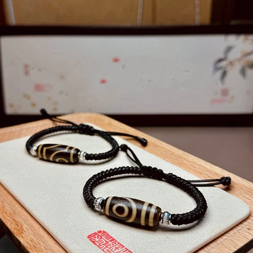 Six-eye dzi bead bracelet front view displaying six hand-painted eyes arranged symmetrically on natural stone