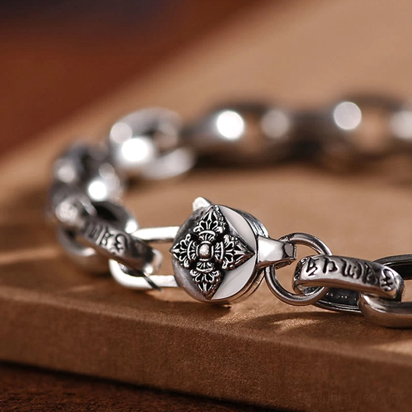 Extreme close-up of sterling silver buddhist mantra bracelet carved clasp with polished vintage silver finish detail