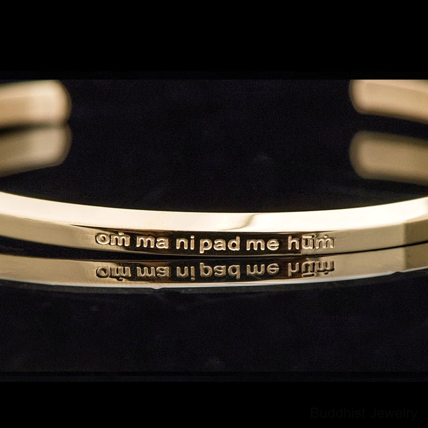 Close-up of engraved om mani padme hum text on titanium bracelet
