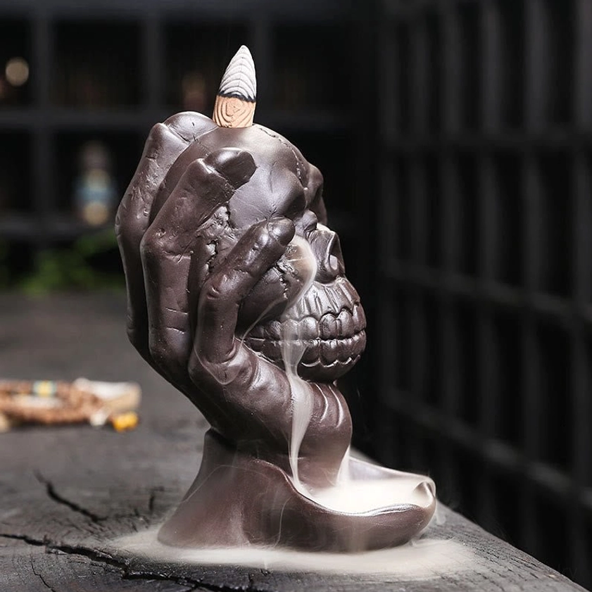 Right profile view of purple clay skull backflow incense holder showing detail and descending smoke pattern