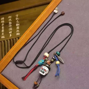 Buddhist skull bone pendant necklace with braided cord and decorative beads - overhead view