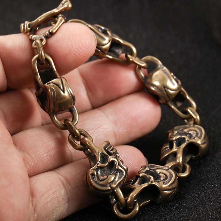 Copper brass skull protection bracelet close-up showing intricate carving and craftsmanship of individual skull motifs