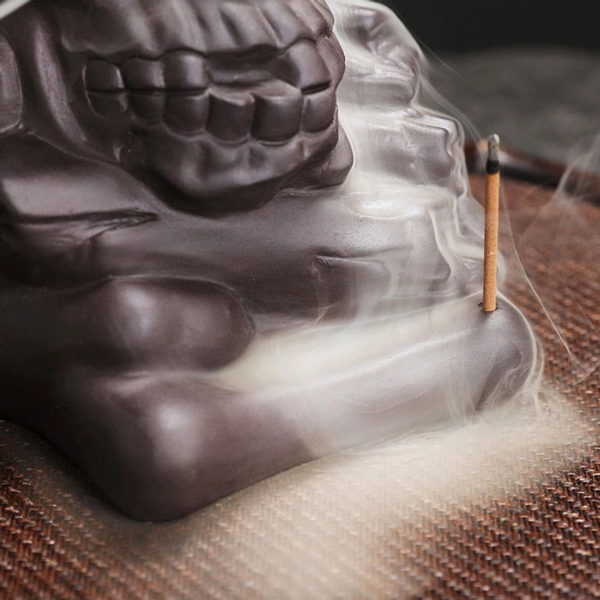 Close-up detail of skull incense burner showing craftsmanship and facial structure with stick incense