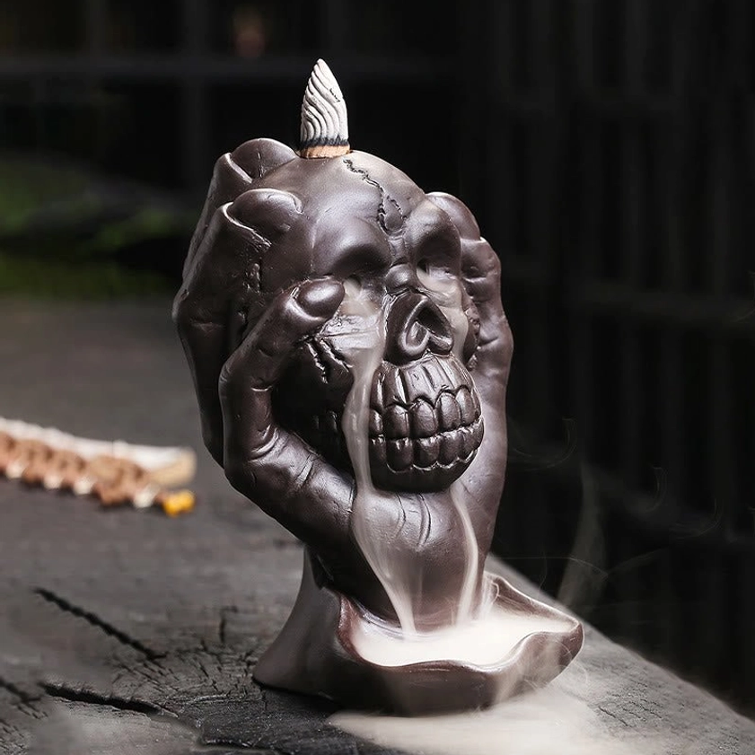 Skull incense burner front right angle with incense cone on top and cascading smoke - handcrafted purple clay meditation tool