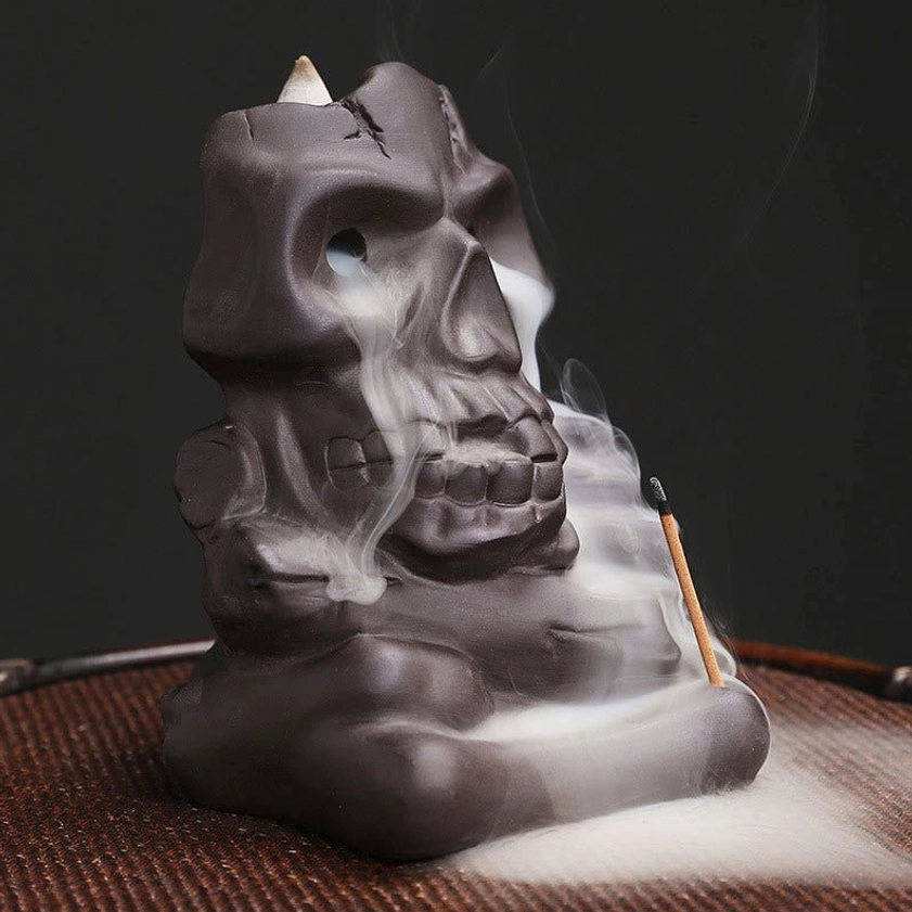 Handcrafted purple clay skull incense holder three-quarter angle showing artistic skull details and smoke flow