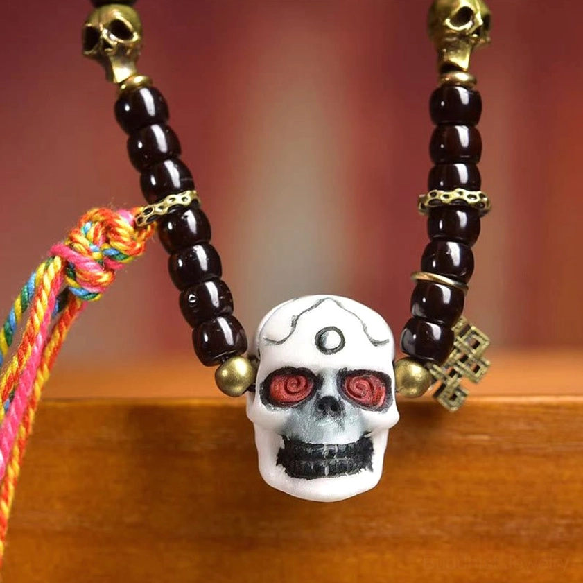Detailed close-up of coconut shell beads and white skull pendant on Buddhist bracelet