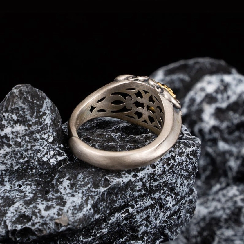 Back view of handmade skull ring displaying hollow carved inner band with partial gold accents