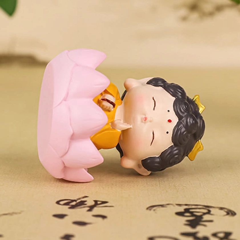 Reclining Sleeping Buddha resin figurine detached from pink lotus shell base on desktop